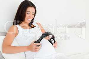 Frontal view of a beautiful pregnant woman putting headphones on