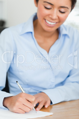 Frontal view of an attractive woman writing on a sheet of paper