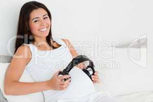 Frontal view of an attractive pregnant woman putting headphones