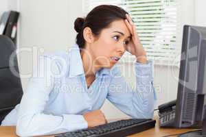 Beautiful upset woman looking at a computer screen while sitting