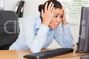 Good looking upset woman looking at a computer screen while sitt