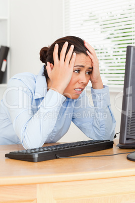 Charming upset woman looking at a computer screen while sitting