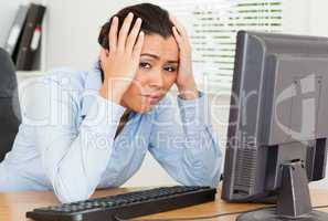 Lovely upset woman looking at a computer screen while sitting
