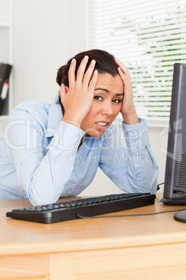 Pretty upset woman looking at a computer screen while sitting