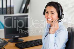 Beautiful woman wearing a headset and discussing while sitting