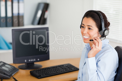 Good looking woman wearing a headset and discussing while sittin