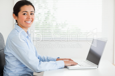 Attractive woman working with her laptop and posing while sittin