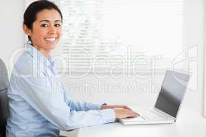 Attractive woman working with her laptop and posing while sittin