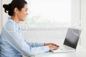 Attractive woman working with her laptop and typing while sittin