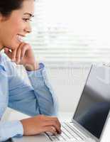 Good looking woman working with her laptop and typing while sitt