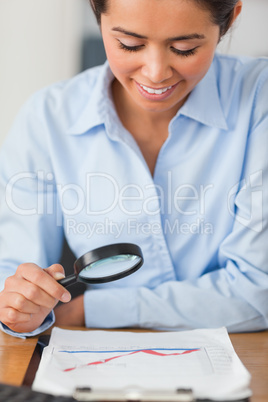 Beautiful woman using a magnifyng glass