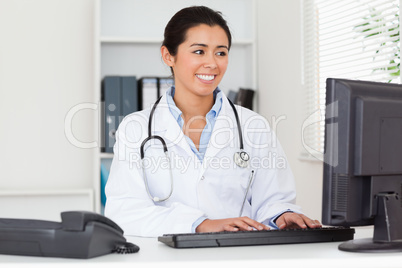 Attractive woman doctor typing on a keyboard