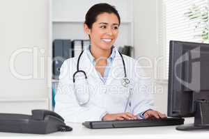 Attractive woman doctor typing on a keyboard