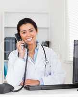Good looking woman doctor on the phone while sitting