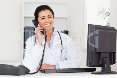 Lovely woman doctor on the phone while sitting