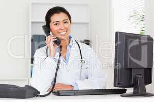 Lovely woman doctor on the phone while sitting