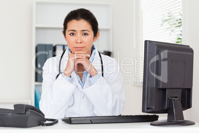 Lovely worried woman doctor looking at the camera while sitting