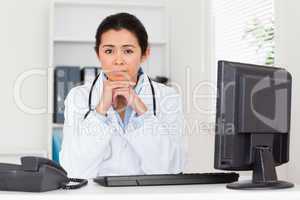 Lovely worried woman doctor looking at the camera while sitting