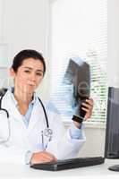 Good looking female doctor looking at a x-ray