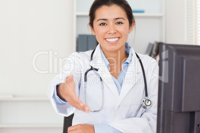 Attractive female doctor inviting somebody to seat while looking