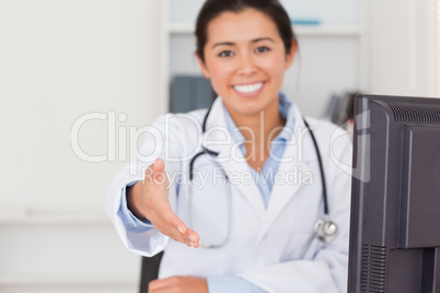 Beautiful female doctor inviting somebody to seat while looking