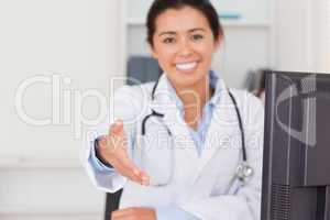 Beautiful female doctor inviting somebody to seat while looking