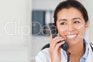 Good looking female doctor on the phone and posing