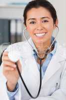 Good looking female doctor using a stethoscope while looking at