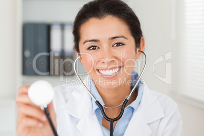 Beautiful female doctor using a stethoscope while looking at the