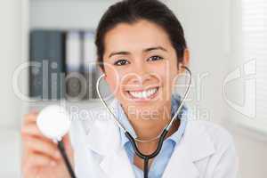 Beautiful female doctor using a stethoscope while looking at the