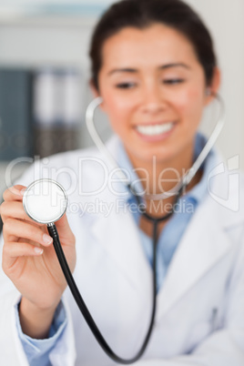 Gorgeous female doctor using a stethoscope while looking at the