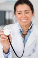 Gorgeous female doctor using a stethoscope while looking at the