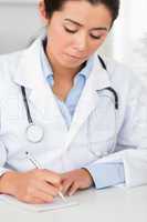 Attractive female doctor writing on a scratchpad