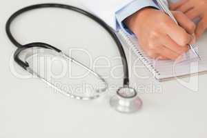 Female doctor writing on a scratchpad