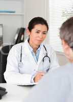 Pretty female doctor listening carefully to a patient