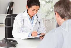 Pretty female doctor consulting the patient's medical analysis