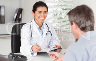 Patient giving his attractive woman doctor a piece of paper