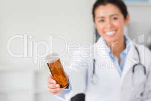 Gorgeous smiling doctor holding a box of pills