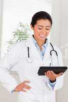 Attractive female doctor with a stethoscope holding a notebook w