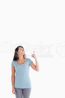 Good looking woman showing a copy space with her finger while st
