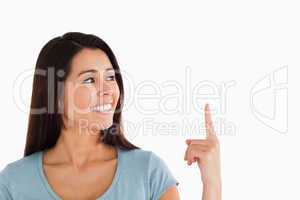 Portrait of a beautiful woman pointing at a copy space while sta