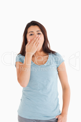 Beautiful tired woman yawning while standing