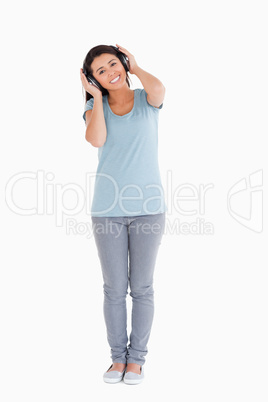 Beautiful woman using her headphones while standing