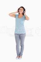 Attractive woman using her headphones while standing