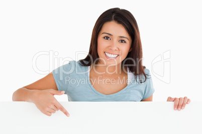 Portrait of a gorgeous woman pointing at a board