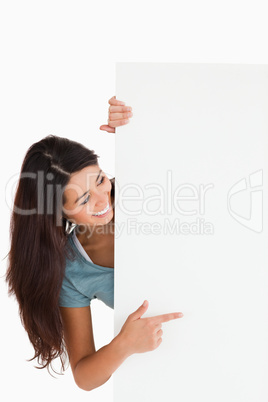 Pretty woman pointing at a board