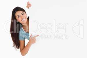 Smiling woman pointing at a board