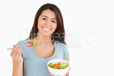 Beautiful woman eating a bowl of salad