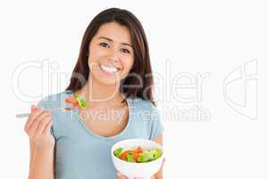 Beautiful woman eating a bowl of salad