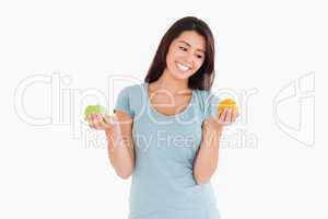 Beautiful woman holding an apple and an orange
